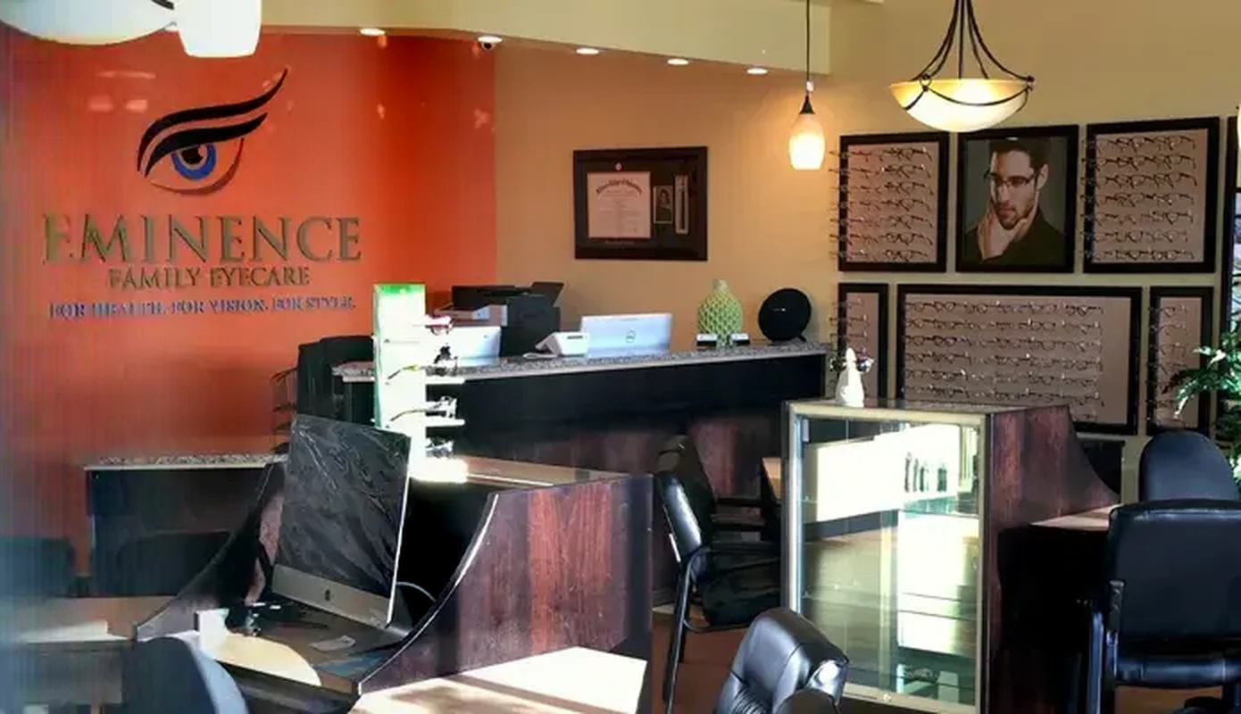The reception at Eminence Family Eyecare in Alpharetta, Georgia, with the practice name on the wall and the frame gallery behind